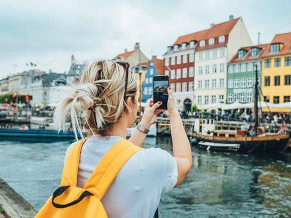 Woman taking a photo on her phone in Amsterdam