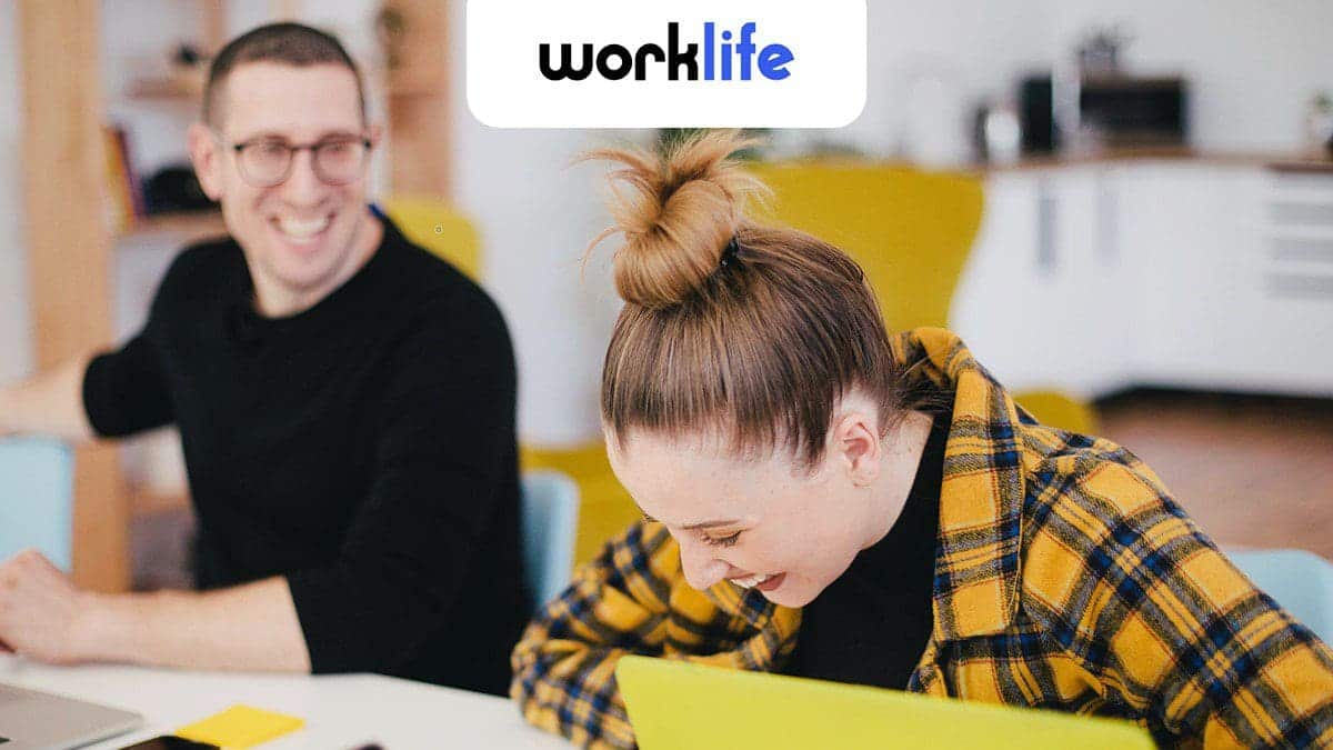 Woman laughing with a coworker about the vacation she booked using arrivia's employer-sponsored travel benefits platform