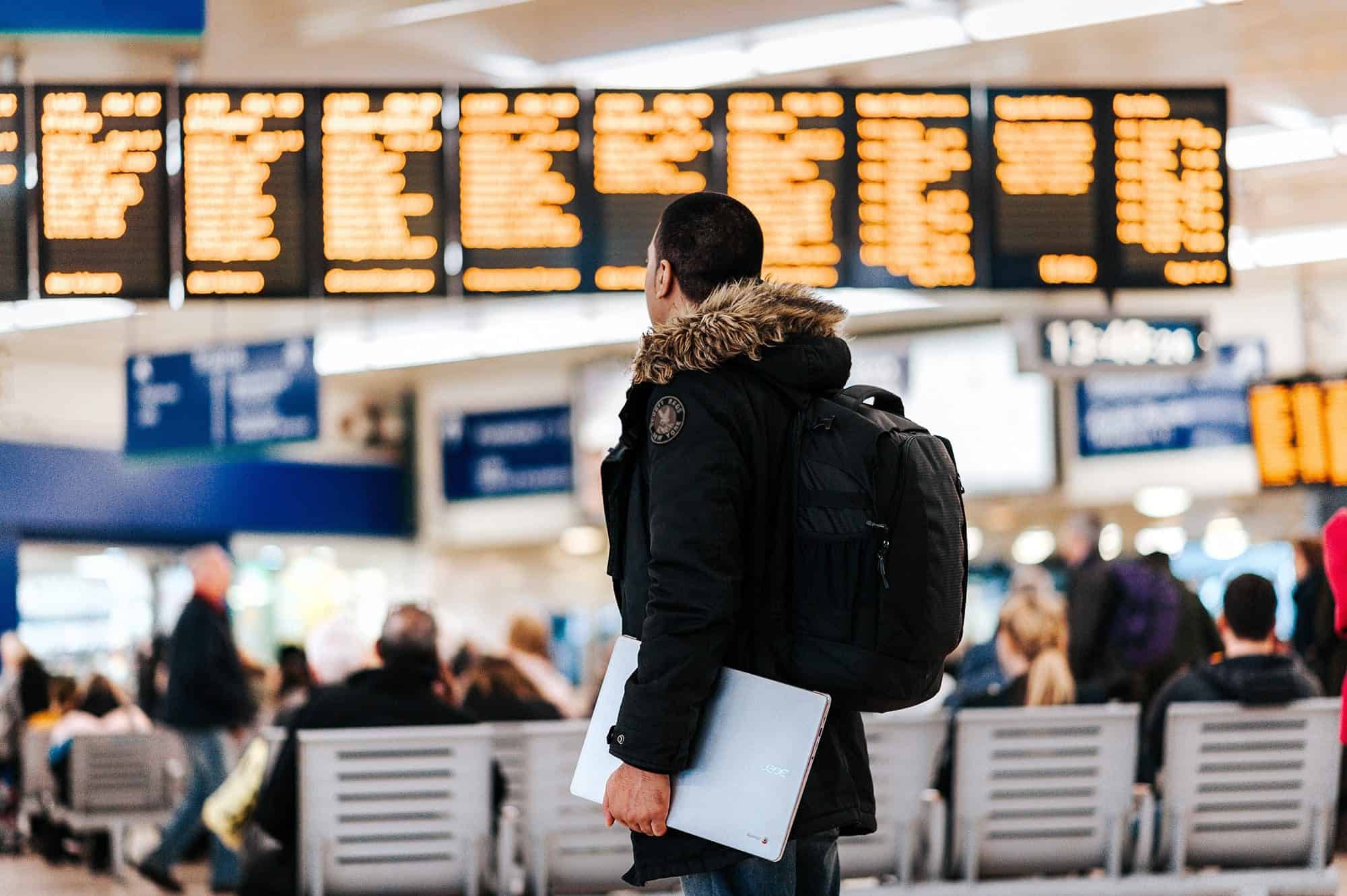 Man seen at the airport waiting for a flight booked with a travel credit card.