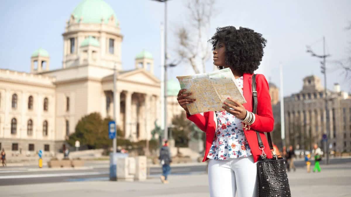 Women holding a paper map on a vacation booked using a loyalty program.