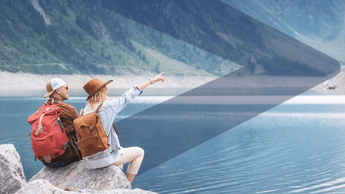 an adventurous couple out hiking and pointing at the lake