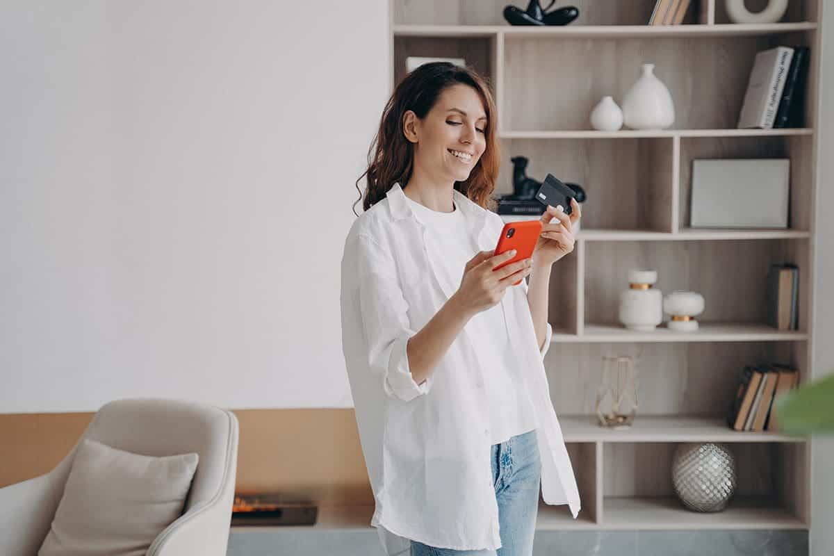 Woman-holding-a-phone-and-credit-card-for-a-marketing-membership