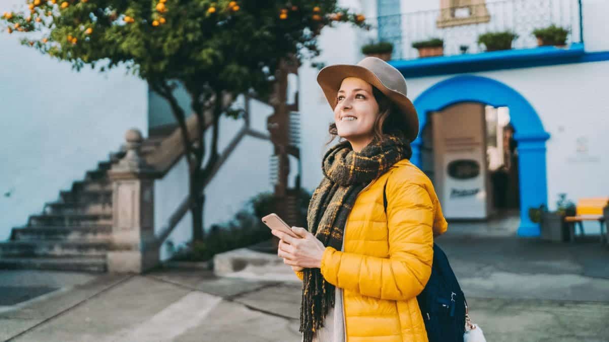 Woman influencer taking pictures while on a trip with her smart phone. 