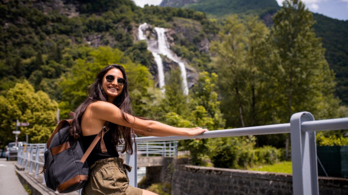 A woman holding onto a rail while hiking up a mountain booked from a travel membership program.