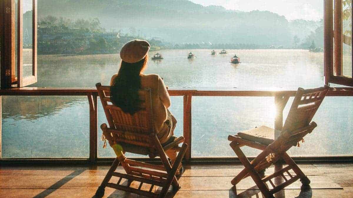 A woman sitting on a cruise deck booked through loyalty travel customer service.