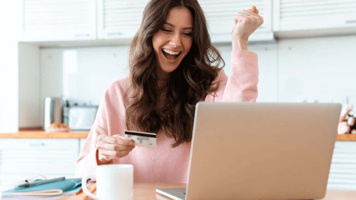 A woman using a laptop to shop with credit card rewards programs.