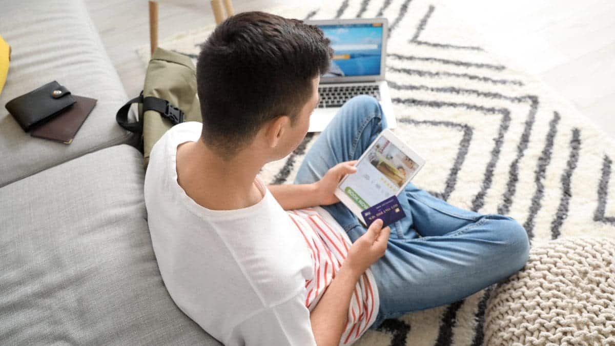 Man using a laptop computer to book travel on a white label travel portal.