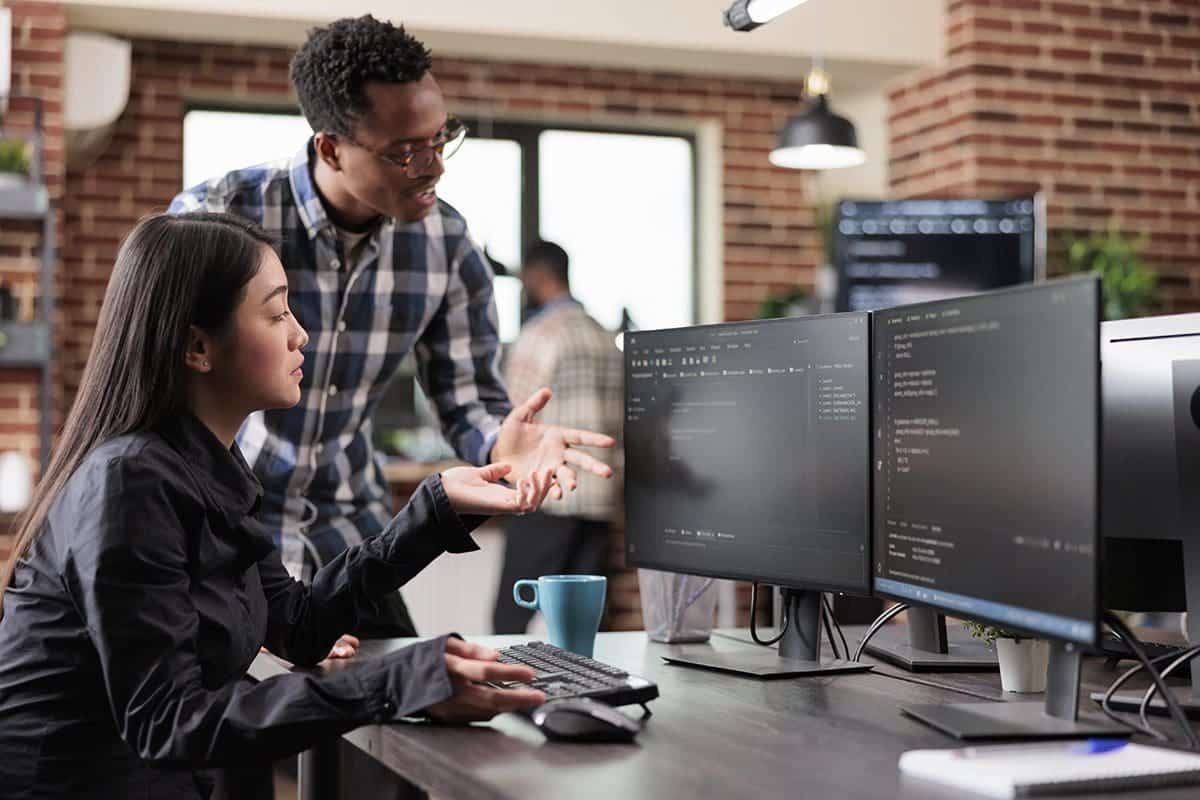 Multi-ethnic cybersecurity team looking at multiple screens