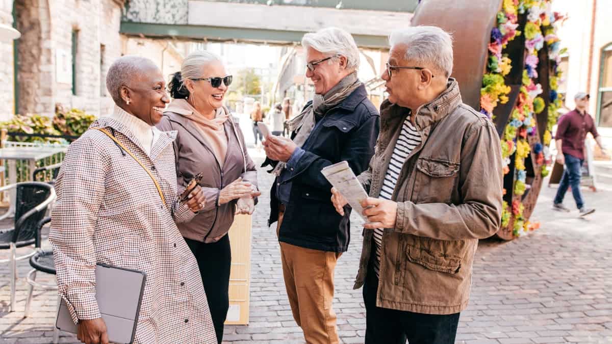 A group of travelers standing outside laughing.