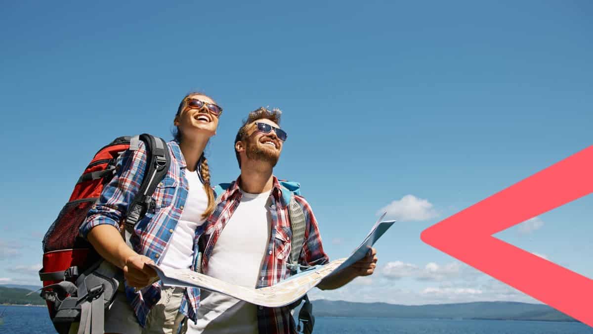 A man and a woman on vacation holding a map.