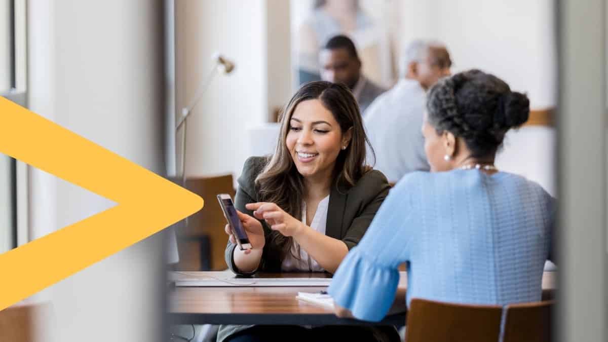 Bank employee showing a customer the mobile wallet solutions.