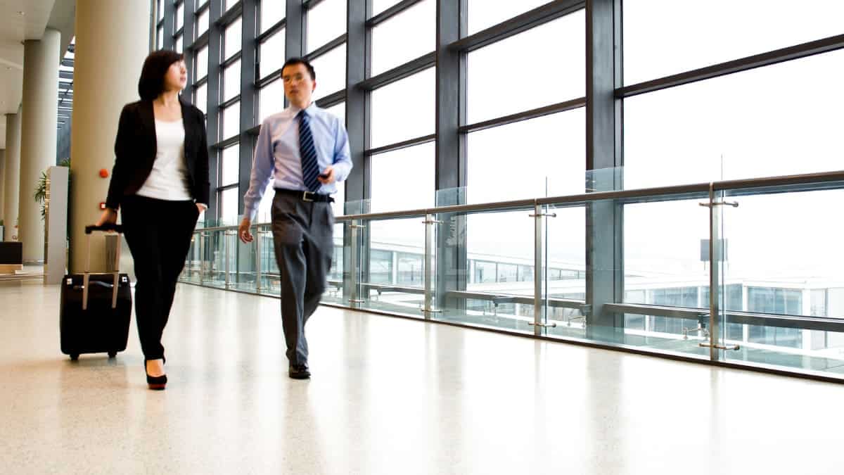 A businessman and woman walking through an airport.