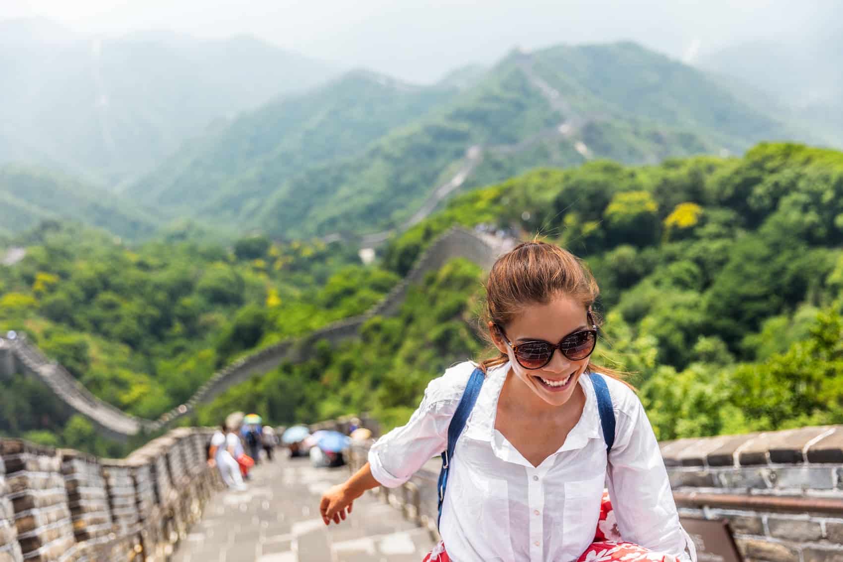 Woman traveler hiking great wall enjoying her summer vacation.