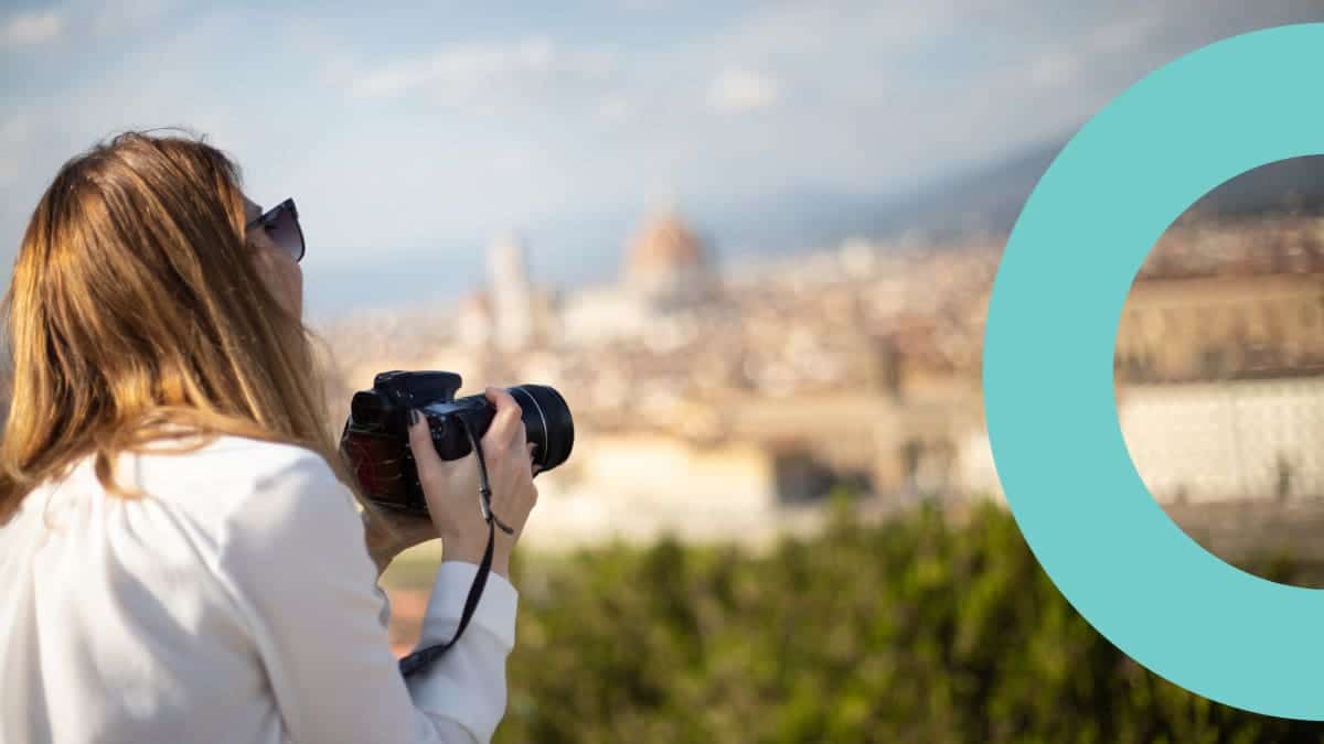 A woman with a camera taking photographs of the city view.