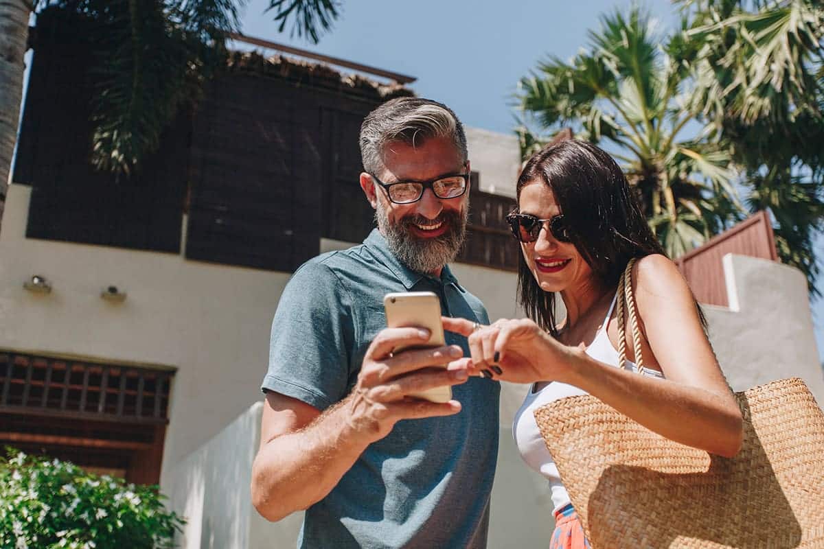 A couple using AI-powered tools provided by their loyalty program while on vacation.