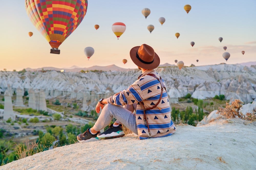 Person enjoying loyalty rewards, watching hot air balloons
