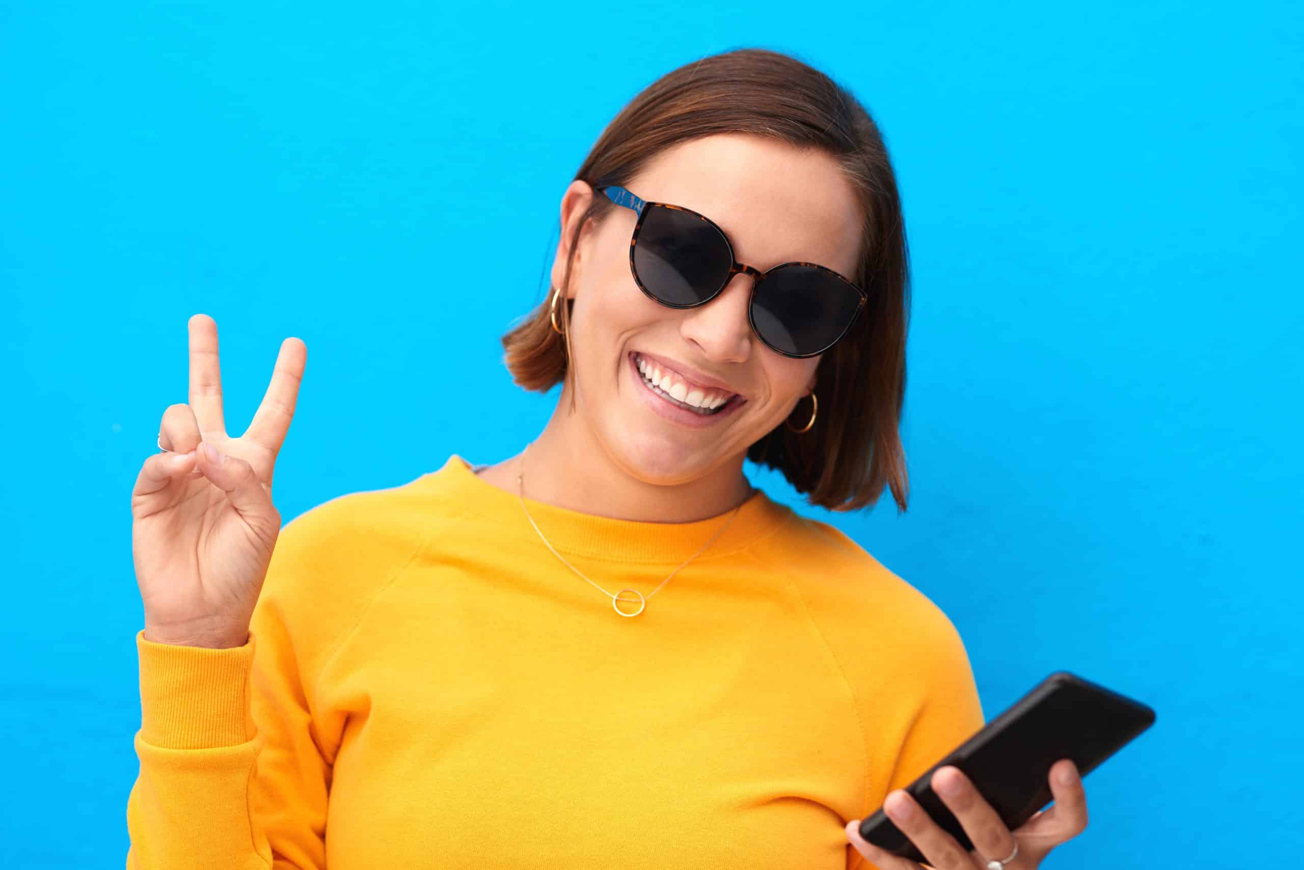 Woman smiling and holding a phone while enjoying loyalty rewards benefits