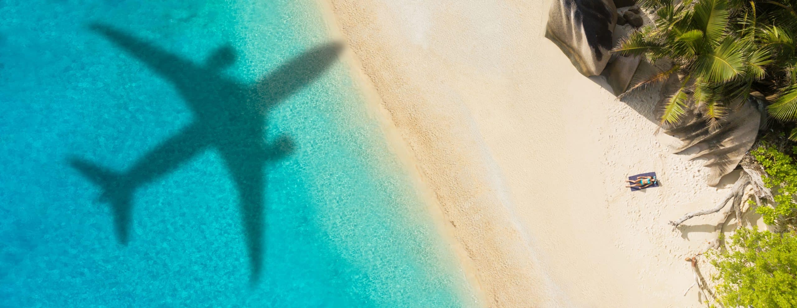 Aerial view of tropical beach with airplane shadow