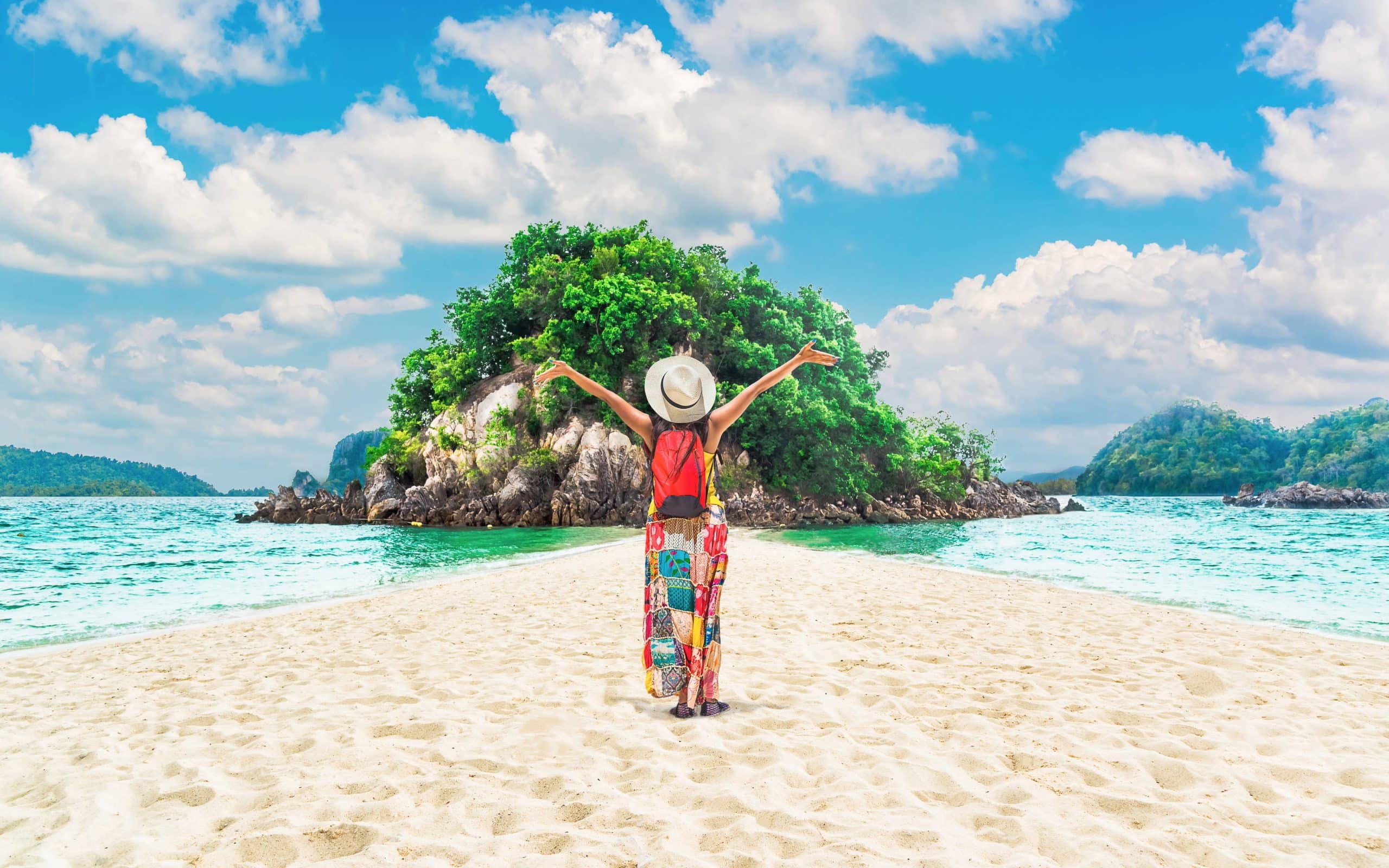 Traveler facing island on tropical beach