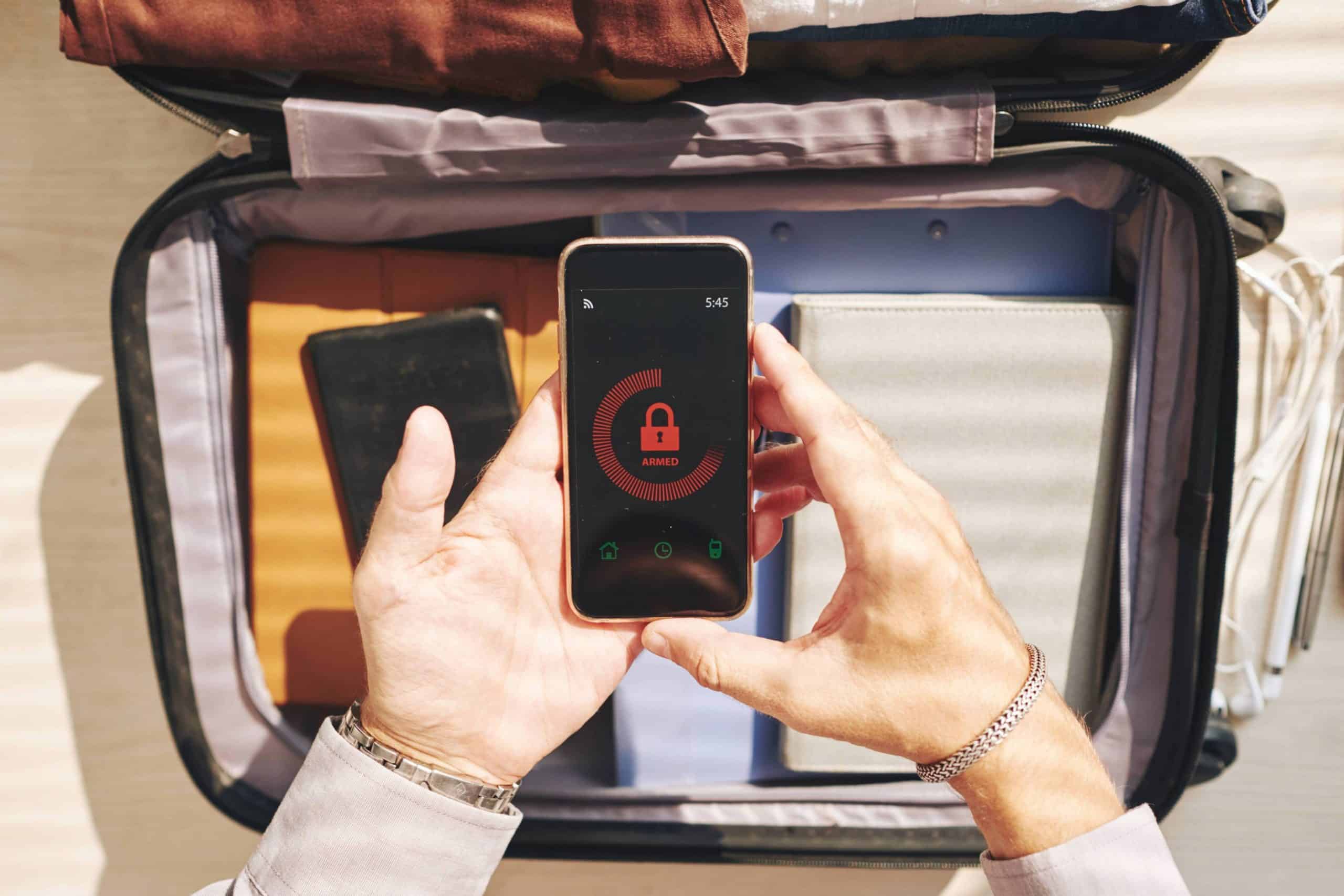 Person packing a suitcase while viewing a security lock on a mobile travel app