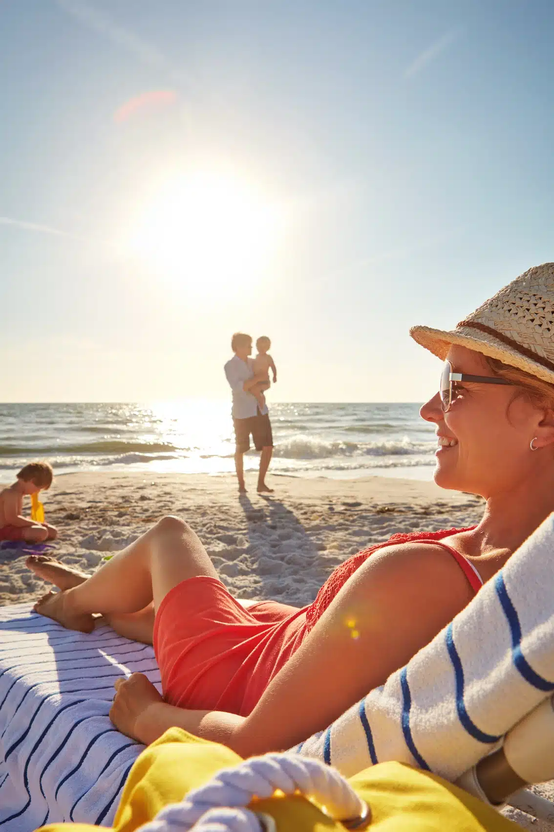 woman lounging on the beach with family