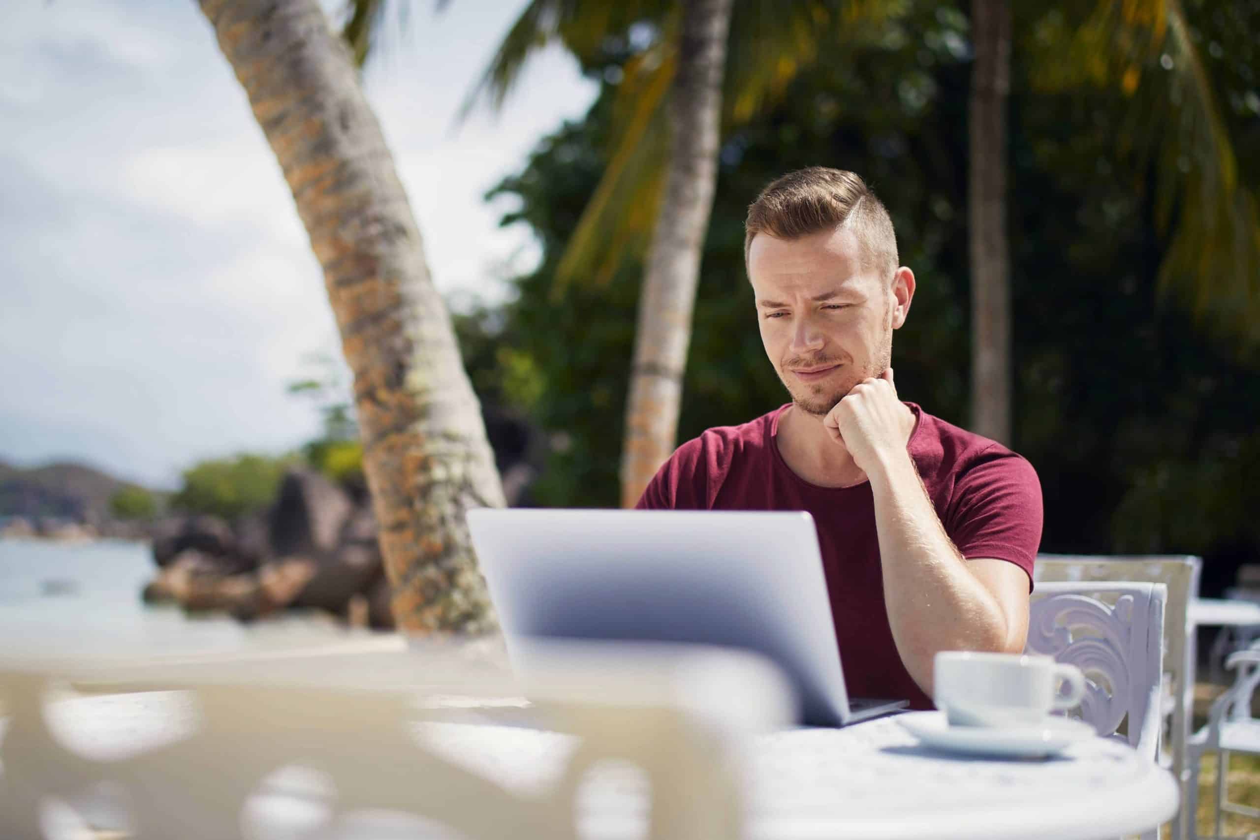 Man working on a laptop in a tropical location