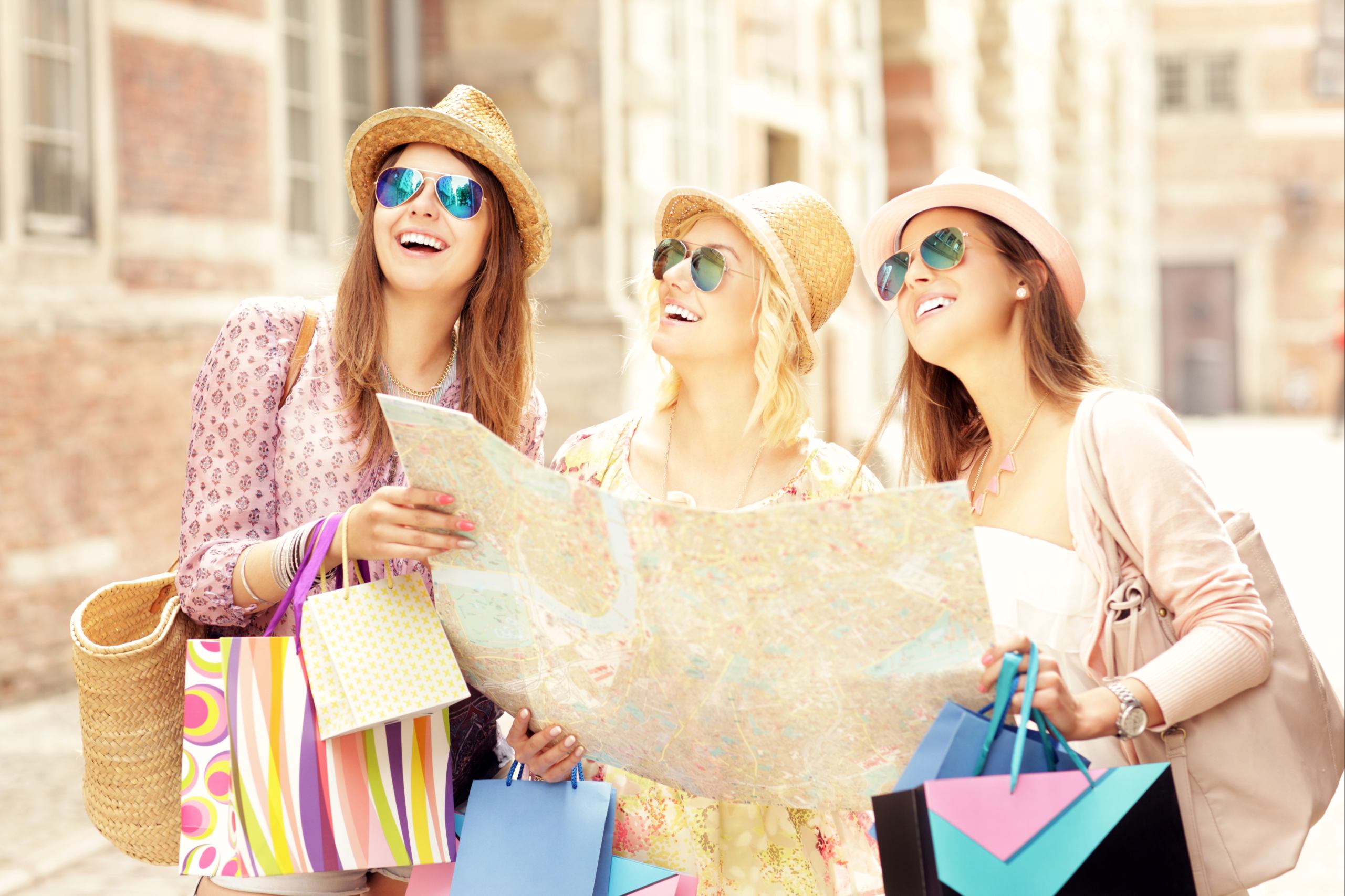 a group of three women using a map while traveling abroad